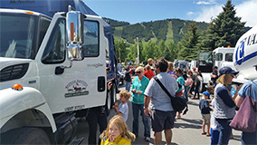 Westbank Sanitation garbage truck surrounded by people at a town event.
